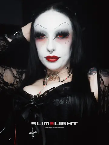 A guest with a white-painted face, dark red lips and black lace.