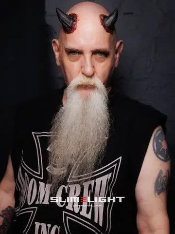 A guest with painted horns on a shaved head and a long white beard.